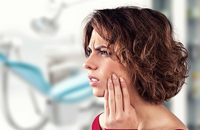 woman holding jaw in pain