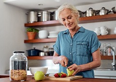 Woman smiling while preparing snack in kitchen