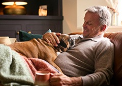 Man relaxing at home and petting his dog
