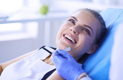 woman smiling in blue exam chair