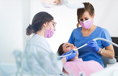 two assistants cleaning patients smile