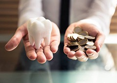 Person holding change and a model of a tooth