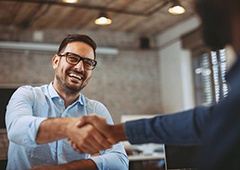 Smiling man shaking hands with an implant dentist in Brownstown