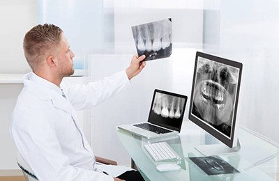 Implant dentist in Brownstown examining X-rays