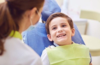 little boy smiling in dental chair