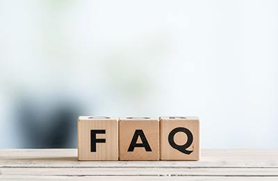Three wooden letter blocks spelling FAQ