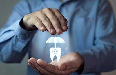 tooth with umbrella over it in hands