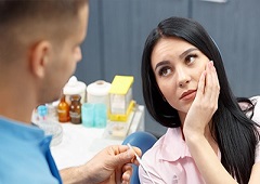 woman looking at dentist in pain