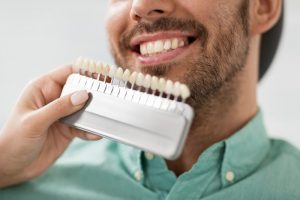 cosmetic dentist in brownstone discussing porcelain veneers with a patient