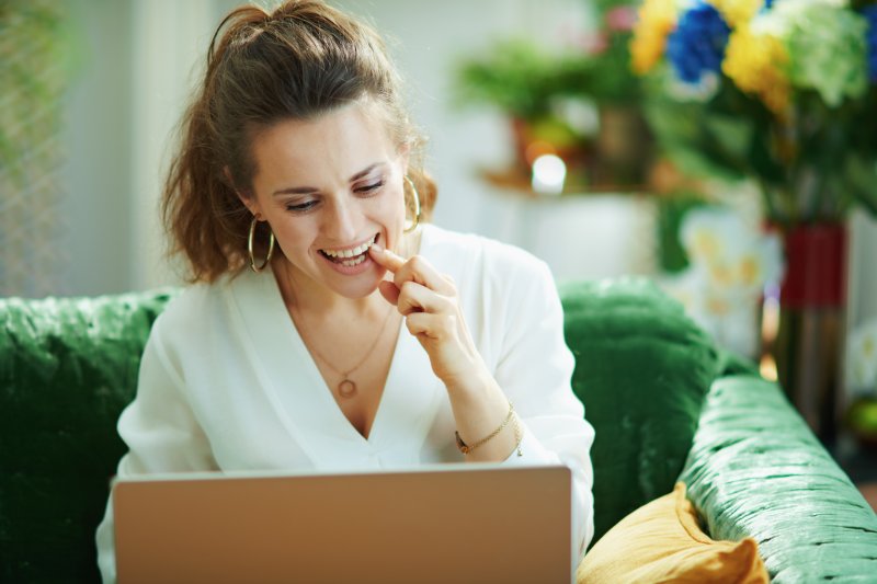 Woman learning about smoking and dental implants on a laptop