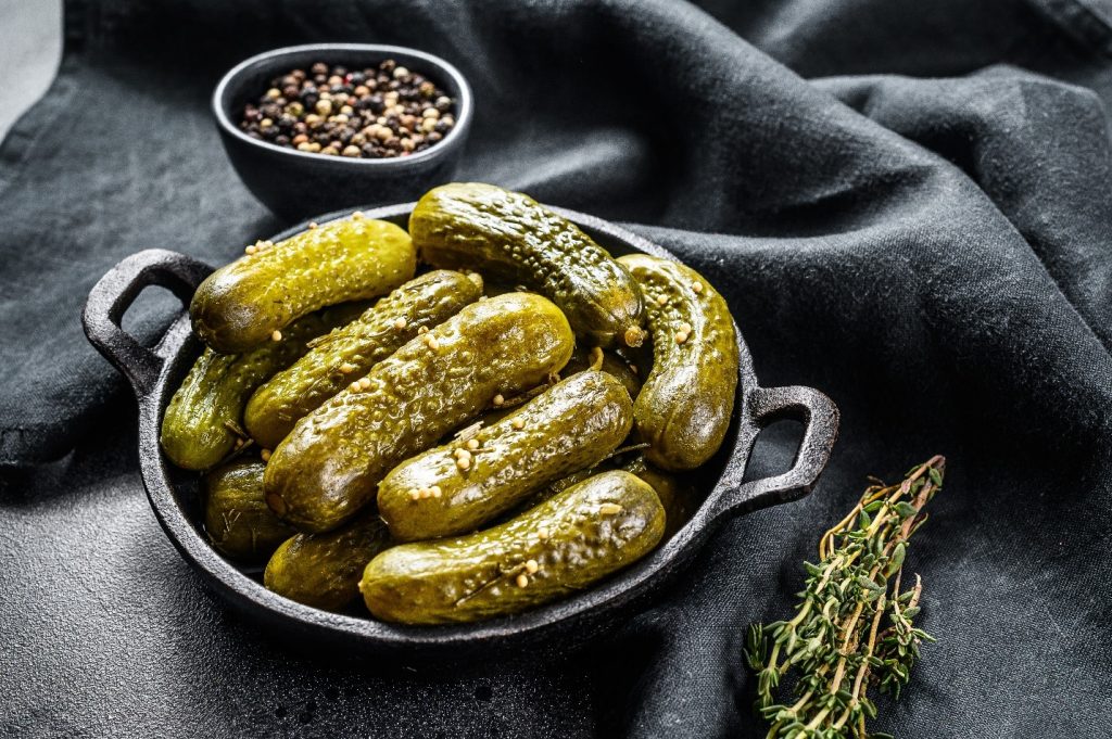 cast iron container of pickles on black cloth