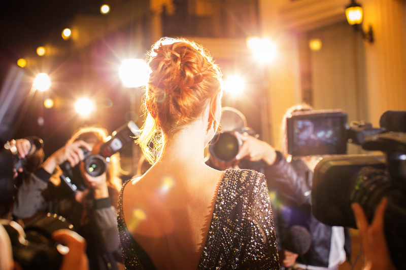 Celebrity with dental implants walking through an adoring crowd
